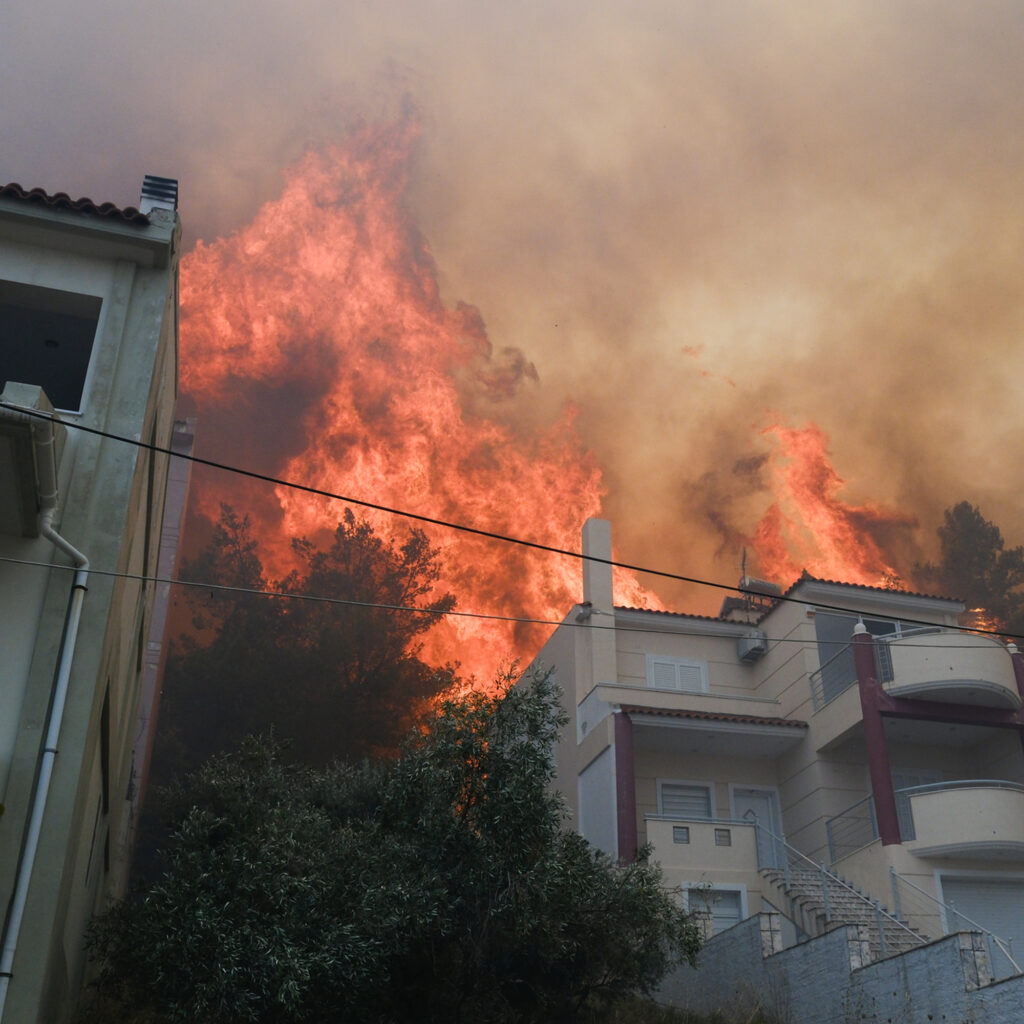Active fire engulfing apartment building with flames and smoke